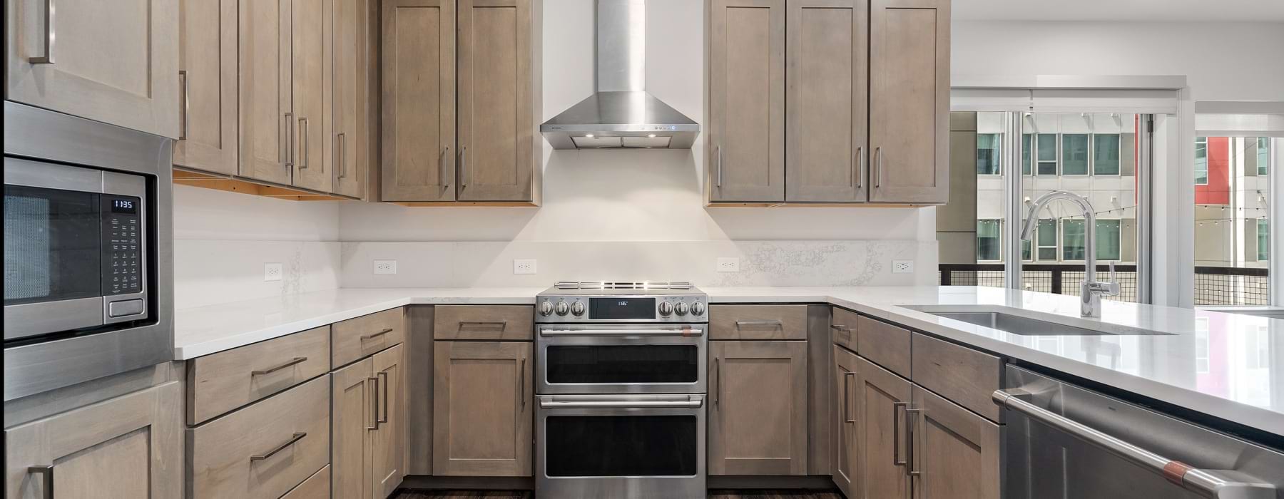 Overview of kitchen with brown cabinets and stainless steel appliances