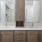 Bathroom with double vanity sinks, brown cabinets, and large framed mirrors