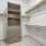 Walk-in closet with racks on both sides and shelving on the back wall