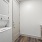 Storage room with stackable washer and dryer as well as brown cabinets
