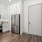 Entryway and kitchen with white cabinets and stainless steel appliances