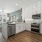 Kitchen with white cabinets and stainless steel appliances overlooking living room