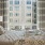 Bedrom with queen sized bed, two nightstands and big window overlooking courtyard